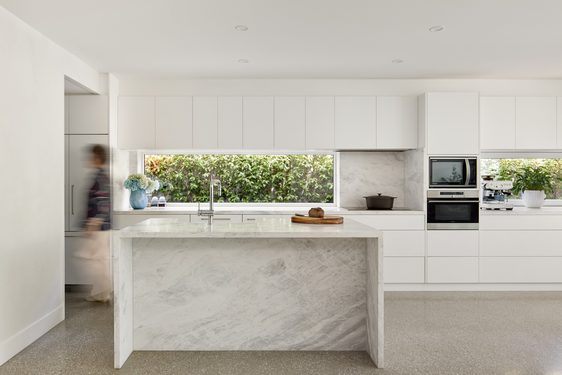 Kitchen with marble island and window splashback